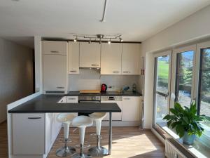 a kitchen with white cabinets and a black counter top at Ferienwohnung Heid in Rettenberg
