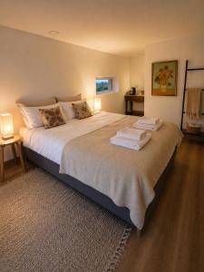 a bedroom with a large bed with towels on it at Quinta Farm Stay - Silence and Nature Retreat in Lousã