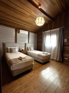 a bedroom with two beds and a chandelier at Ericeira Camping in Ericeira