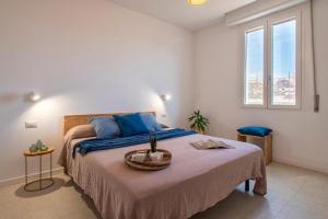 a bedroom with a bed with blue pillows and a window at Opera Rooms Alghero in Alghero