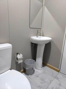 a bathroom with a toilet and a sink and a mirror at Chill House Khaokho in Khao Kho