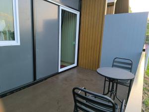 a patio with a table and chairs on a balcony at Chill House Khaokho in Khao Kho