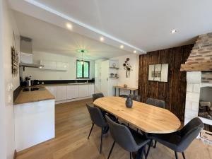 a kitchen and dining room with a wooden table and chairs at Ferme du Bien Hêtre Gîte Cosy in Saint-Arnoult