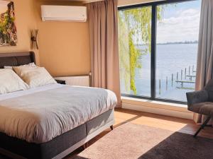 a bedroom with a bed and a large window at Weromerie Premium Hotel and Apartment in Wormer