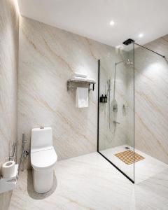 a bathroom with a toilet and a glass shower at Tiraya Luxury Riverside Hotel & Café in Gushaini +27 photos
