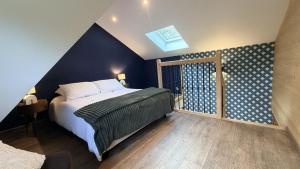 a bedroom with a bed and a blue wall at Ferme du Bien Hêtre Gîte Cosy in Saint-Arnoult