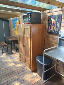 a room with a tv on top of a wooden cabinet at De smishoeve "Herdershut" in Heers
