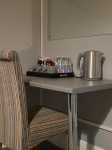 a table with a tea kettle and water bottles on it at Central Guest House in Newport