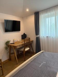 a bedroom with a desk and a bed and a television at La Cubanita in Kojsko