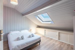 a bedroom with a bed and a skylight at Waterfront in Lugrin