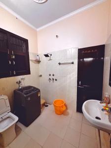a bathroom with a sink and a shower and a toilet at The Bel - Monte Stays in Panchkula