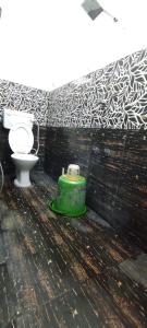 a bathroom with a toilet and a green container at Hotel vasaavi Rameswaram in Rāmeswaram