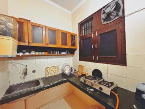 a kitchen with a sink and a stove in it at The Bel - Monte Stays in Panchkula