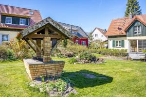 a garden with a wooden structure in the grass at Bungalow am Haussee in Himmelpfort