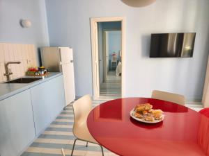 a red table in a kitchen with a plate of food on it at Case Borgo Vacanze in Letojanni