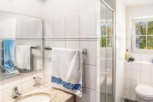 a white bathroom with a sink and a toilet at Bungalow am Haussee in Himmelpfort +20 photos
