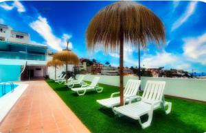 a group of white chairs and an umbrella at Ocean Paradise View in Adeje