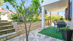 a patio with a green rug and a chair at Ivanka Studio in Dajla