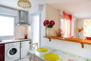 a kitchen with a table and a washing machine at Plein soleil, Capbreton in Capbreton
