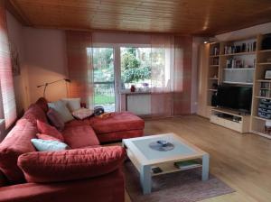 a living room with a red couch and a table at Ferienwohnung Klaus in Ebermannstadt