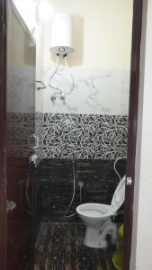 a bathroom with a toilet and a lamp on a wall at Hotel vasaavi Rameswaram in Rāmeswaram +10 photos