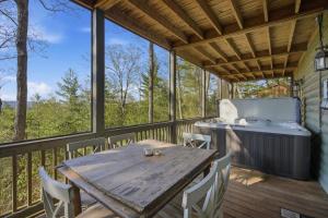 a wooden deck with a wooden table and chairs at Not Your Average Bear Hot Tub in Blue Ridge