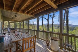 a screened in porch with a wooden table and chairs at Not Your Average Bear Hot Tub in Blue Ridge
