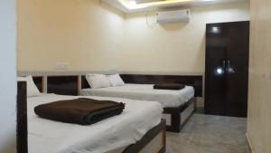 a room with two beds in a room at Hotel vasaavi Rameswaram in Rāmeswaram