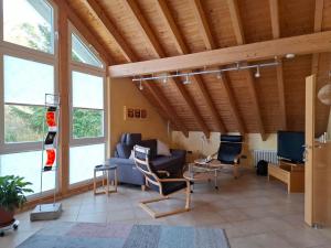 a living room with a couch and chairs and windows at Ferienwohnung Charbi in Simmern