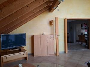 a living room with a television and a staircase at Ferienwohnung Charbi in Simmern