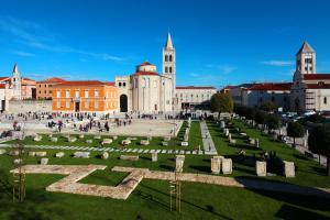 a group of people walking around a cemetery in a city at Apartment Zubčić in Zadar