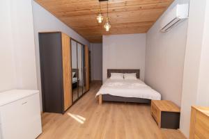 a bedroom with a bed and a wooden ceiling at Hotel Chateau Ochia in Koromkhet'i