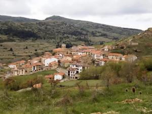 a group of houses on a hill in a field at Casa Senderuela by CARDI Suites in Valdelinares