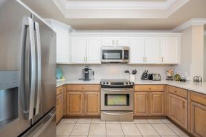 a kitchen with wooden cabinets and a stainless steel refrigerator at Phoenix IX 707 in Orange Beach