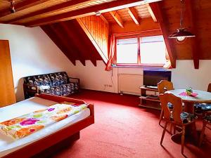 a room with a bed and a table and a couch at Gästehaus Bettina in Sipplingen
