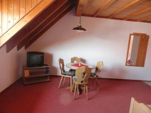 a room with a table and chairs and a tv at Gästehaus Bettina in Sipplingen