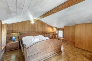 a bedroom with a large bed in a room with wooden walls at Private Green Oasis - Terrace - Happy Rentals in Tenno