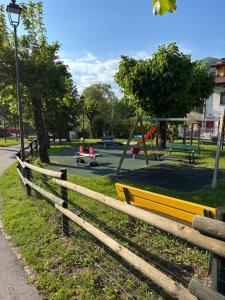 a wooden fence in a park with a playground at La dolce vita in Zelbio