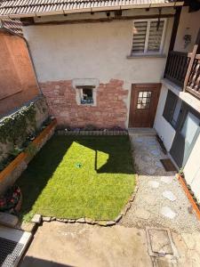 a small yard with grass in front of a house at Chez l'Alsacienne in Andlau