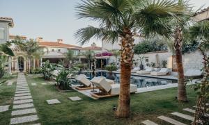 a house with palm trees and a swimming pool at Alaçatı Lotus Bahçe in Alaçatı