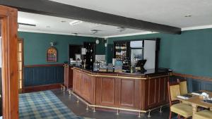 a bar in a restaurant with blue walls at The Portland Hotel in Lybster