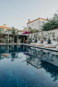a swimming pool with white lounge chairs next to a building at Alaçatı Lotus Bahçe in Alaçatı +19 photos