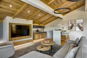 a living room with a couch and a tv at Hotel Alpenhof in Bad Wiessee