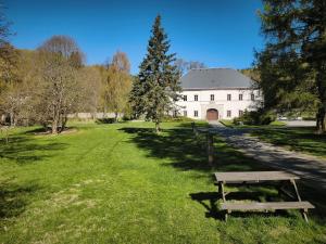 a bench sitting in the grass in front of a building at Zámeček Bischofstein in Teplice nad Metují