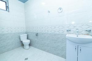 a white bathroom with a toilet and a sink at Hotel Chateau Ochia in Koromkhet'i +17 photos