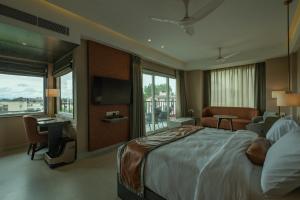 a bedroom with a large bed and a large window at Hotel Tea County in Dibrugarh +65 photos