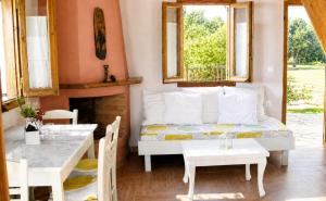 a living room with a bed and a table and chairs at Anerada Houses - Seaviews Above Egremni in Lefkada in Athani