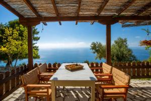 a table and chairs with a view of the ocean at Anerada Houses - Seaviews Above Egremni in Lefkada in Athani