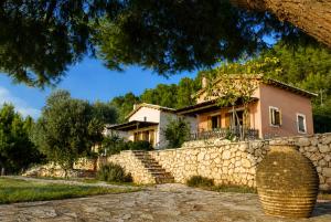 a house with a stone fence and a stone wall at Anerada Houses - Seaviews Above Egremni in Lefkada in Athani