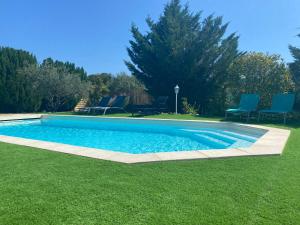 a swimming pool in a yard with blue chairs at La Bastide in Saint-Saturnin-lès-Apt +10 photos